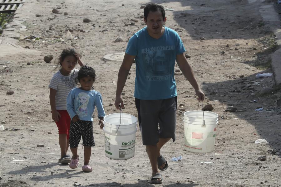 Imagen de archivo de un hombre trasladando baldes con agua en Tegucigalpa, Honduras. (Xinhua/Rafael Ochoa)