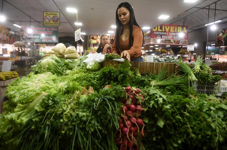 na mujer atiende un puesto de vegetales en un mercado, en Brasilia, Brasil, el 18 de mayo de 2024. (Xinhua/ Lucio Tavora)