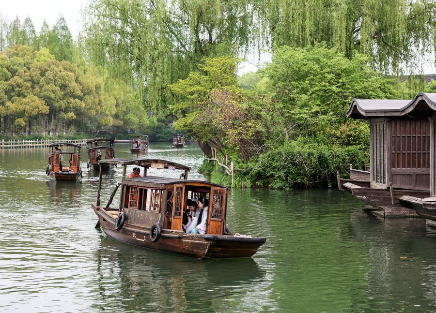 Turistas pasean en botes de remo por el poblado ribereño de Wuzhen, en la ciudad de Jiaxing, provincia oriental china de Zhejiang, el 11 de abril de 2024. (Xinhua/Lan Hongguang)