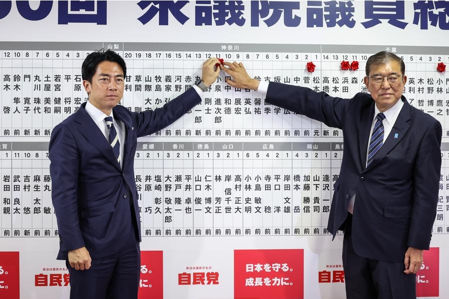 El primer ministro japonés y líder del Partido Liberal Democrático (PLD), Shigeru Ishiba (d), y el exministro de Medio Ambiente de Japón, Shinjiro Koizumi, colocan un alfiler en un tablero mostrando los nombres de los candidatos en la sede del PLD, en Tokio, Japón, el 27 de octubre de 2024. (Xinhua/Takashi Aoyama/Pool)