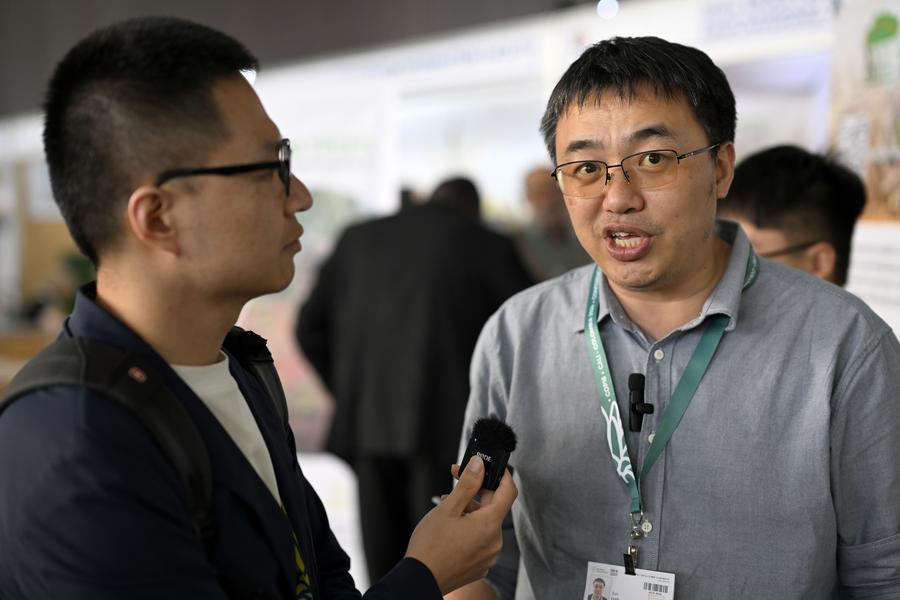 El profesor Luo Xun (d), egresado de la Universidad de Tecnología de Tianjin (China) con doctorado en la Universidad de Illinois, en Estados Unidos, habla durante una entrevista con la Agencia de Noticias Xinhua durante la 16ª Conferencia de las Partes (COP16) sobre la Diversidad Biológica, en la ciudad de Cali, Colombia, el 24 de octubre de 2024. (Xinhua/Liu Yuchen)