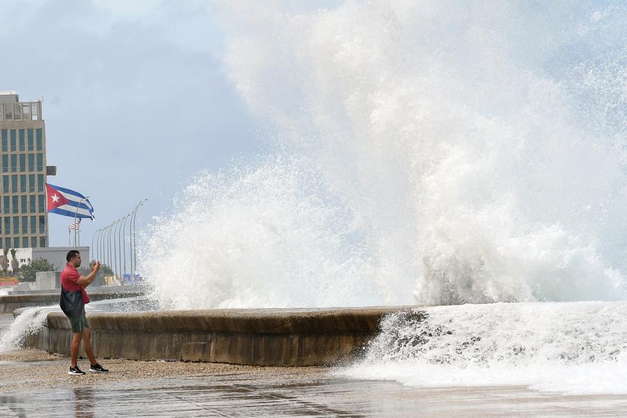 Un hombre toma fotografías a las olas del mar que rompen en el malecón por el paso del huracán Milton, en La Habana, capital de Cuba, el 9 de octubre de 2024. (Xinhua/Joaquín Hernández) 