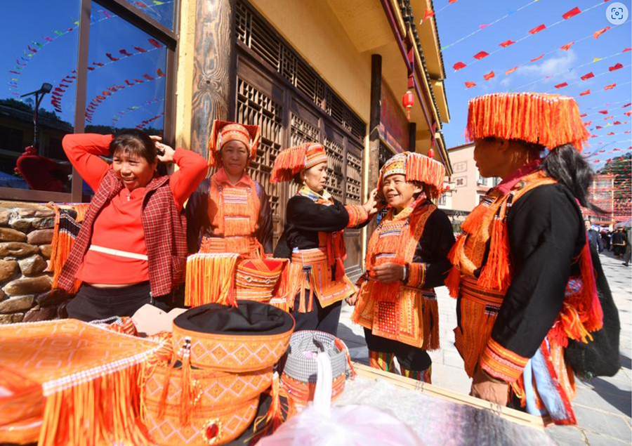 Mujeres mayores del grupo étnico yao seleccionan trajes en una feria folclórica, en el municipio yao de Changping, en el distrito de Mengshan, en la ciudad de Wuzhou, en la región autónoma de la etnia zhuang de Guangxi, en el sur de China, el 23 de octubre de 2024. (Xinhua/Huang Xiaobang) 