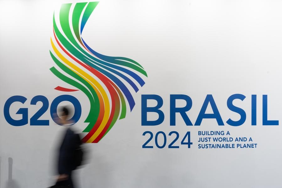 Imagen del 21 de febrero de 2024 de un hombre caminando junto al logotipo del G20 en Río de Janeiro, Brasil. (Xinhua/Wang Tiancong)