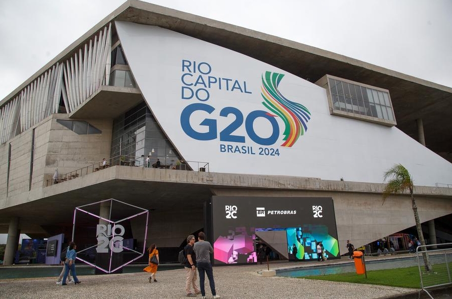 Imagen del 4 de junio de 2024 de personas caminando frente al logo del G20 mientras asisten a la Rio2C 2024 (Conferencia Creativa de Río), el mayor evento de creatividad de América Latina llevada a cabo en la Ciudad de las Artes, en Río de Janeiro, Brasil. (Xinhua/Claudia Martini) 