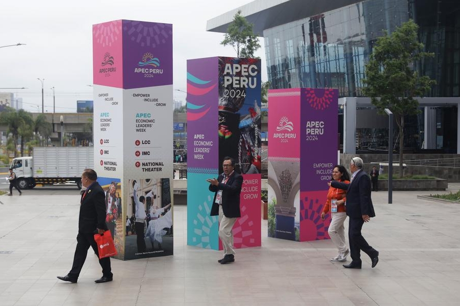 Personas caminan frente a carteles que anuncian el Foro de Cooperación Económica Asia-Pacífico (APEC), en Lima, Perú, el 11 de noviembre de 2024.(Xinhua/Mariana Bazo)