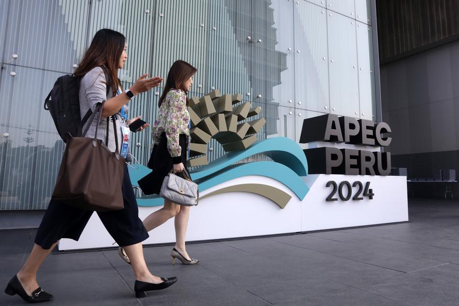 Imagen del 13 de noviembre de 2024 de personas caminando junto al logotipo de APEC 2024 frente al Centro de Convenciones de Lima, en Lima, Perú. La 31ª Reunión de Líderes Económicos de APEC se llevará a cabo en Lima. (Xinhua/Mariana Bazo) 