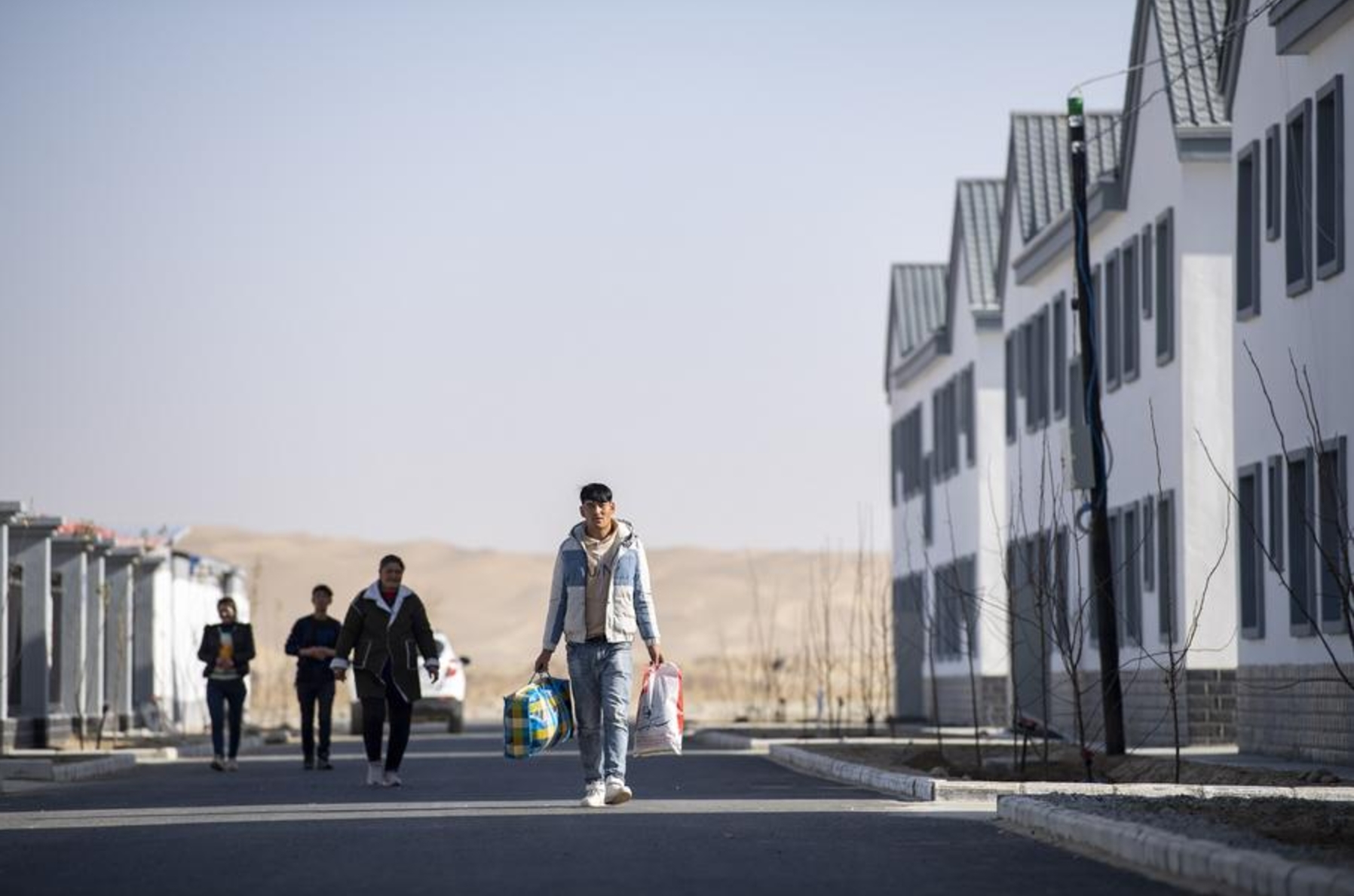 Imagen de archivo del 19 de noviembre de 2019 de personas caminando en una calle en un sitio de reasentamiento de vivienda para los aldeanos del poblado de Darya Boyi en el distrito de Yutian, en la región autónoma de la etnia uygur de Xinjiang, en el noroeste de China. (Xinhua/Hu Huhu) 