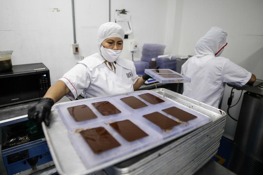 Imagen del 12 de octubre de 2023 de personas trabajando en la producción de chocolates en la fábrica de la empresa Lök Foods, en Bogotá, Colombia. (Xinhua/Str) 