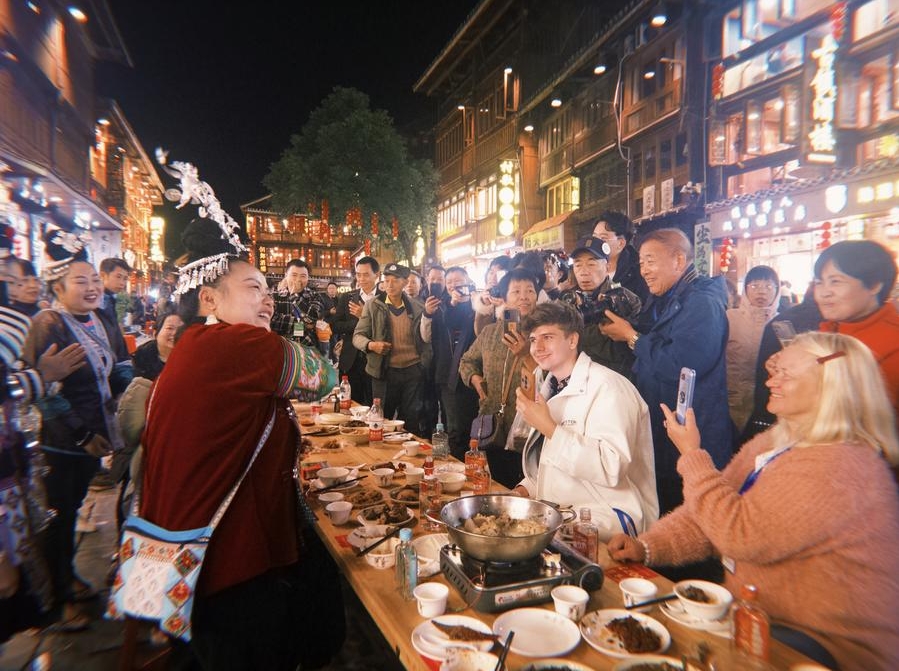 El bloguero alemán Robert Adolf (segundo por la derecha) y su madre, Anna Adolf (primera por la derecha), participan en una celebración del Año Nuevo dong en el poblado de la etnia dong de Zhaoxing, en el distrito de Liping de la provincia de Guizhou, en el suroeste de China, el 30 de noviembre de 2024. (Xinhua/Zhou Xuanni)