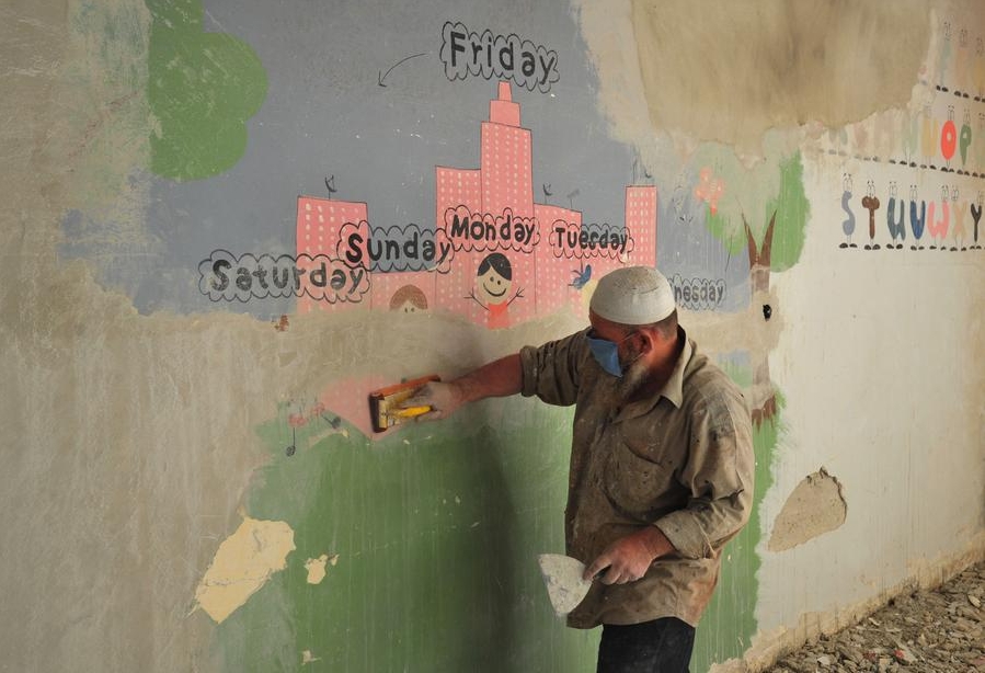 Imagen del 5 de septiembre de 2024 de un trabajador pintando una pared en una escuela, en Guta Oriental, en el este de Damasco, Siria. (Xinhua/Ammar Safarjalani)