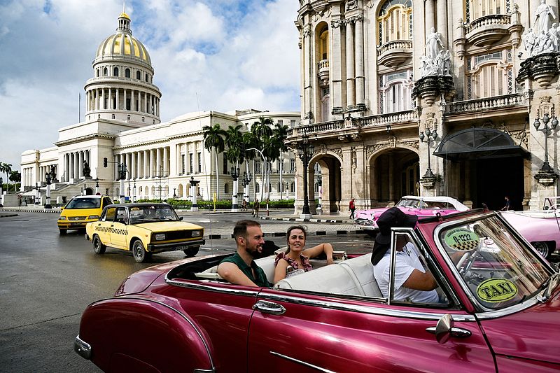 Turistas viajan en un automóvil clásico en La Habana, Cuba, mientras la compañía eléctrica local informa que se ha restablecido la electricidad en la mitad de la ciudad el 21 de octubre de 2024. (Foto: VCG)