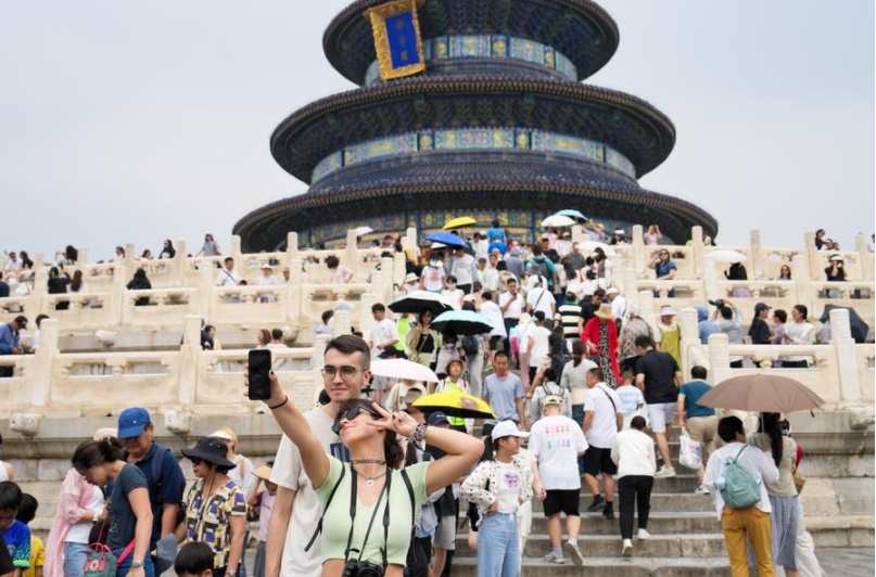 Imagen del 9 de julio de 2024 de turistas extranjeros posando para una fotografía frente al Salón de Oración por las Buenas Cosechas, o Qiniandian, en el parque Tiantan (Templo del Cielo), en Beijing, capital de China. (Xinhua/Ju Huanzong) 