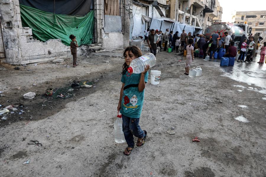 Imagen del 25 de agosto de 2025 de una niña palestina desplazada recolectando agua en un refugio temporal, en el noroeste de la Ciudad de Gaza. (Xinhua/Rizek Abdeljawad)