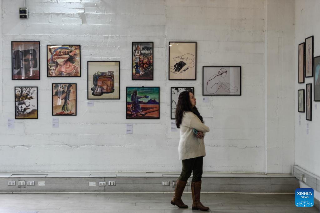 Imagen del 20 de agosto de 2025 de una mujer visitando la exposición "El arte como fuerza transformadora del humanismo" del chileno José Venturelli, en la Biblioteca de Santiago, en Santiago, capital de Chile. Dibujos para un libro clandestino del premio Nobel de Literatura Pablo Neruda, obras creadas en China influenciadas por la estética del país asiático o grabados sobre el movimiento obrero destacan en la exposición "El arte como fuerza transformadora del humanismo" del chileno José Venturelli (1924-1988) que acerca la obra de este laureado artista a los usuarios de la Biblioteca de Santiago. (Xinhua/Jorge Villegas)