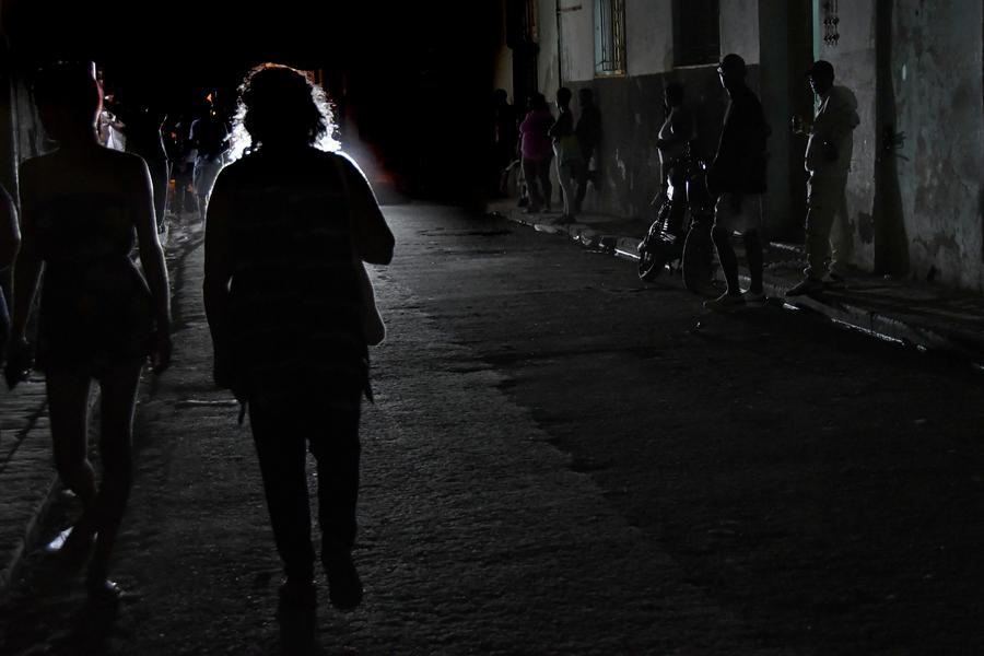 Imagen del 15 de febrero de 2025 de personas caminando por una calle oscura después de un corte del suministro de electricidad, en La Habana, capital de Cuba. (Xinhua/Joaquín Hernández) 