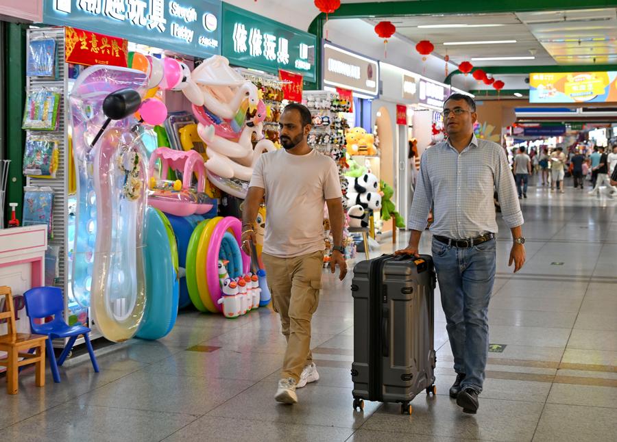 Comerciantes extranjeros llevan una maleta para comprar muestras en el Mercado de Comercio Internacional de Yiwu, en la provincia oriental china de Zhejiang, el 16 de mayo de 2025. (Xinhua/Chen Shuo)