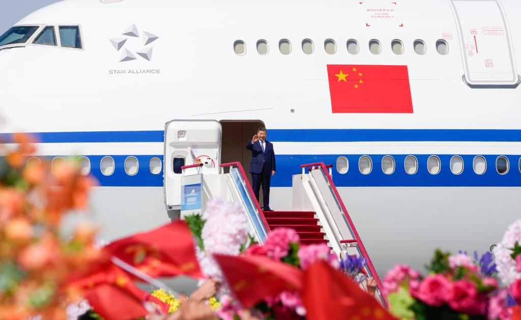 El presidente chino, Xi Jinping, también secretario general del Comité Central del Partido Comunista de China y presidente de la Comisión Militar Central, desembarca y saluda a una multitud que le aclama a su llegada a Urumqi, en la región autónoma uygur de Xinjiang, en el noroeste de China, el 23 de septiembre de 2025. Xi, encabezando una delegación central, llegó el martes a Urumqi, capital de la región autónoma uygur de Xinjiang, para asistir a las actividades conmemorativas por el 70º aniversario de la fundación de la región. (Xinhua/Bi Xiaoyang)