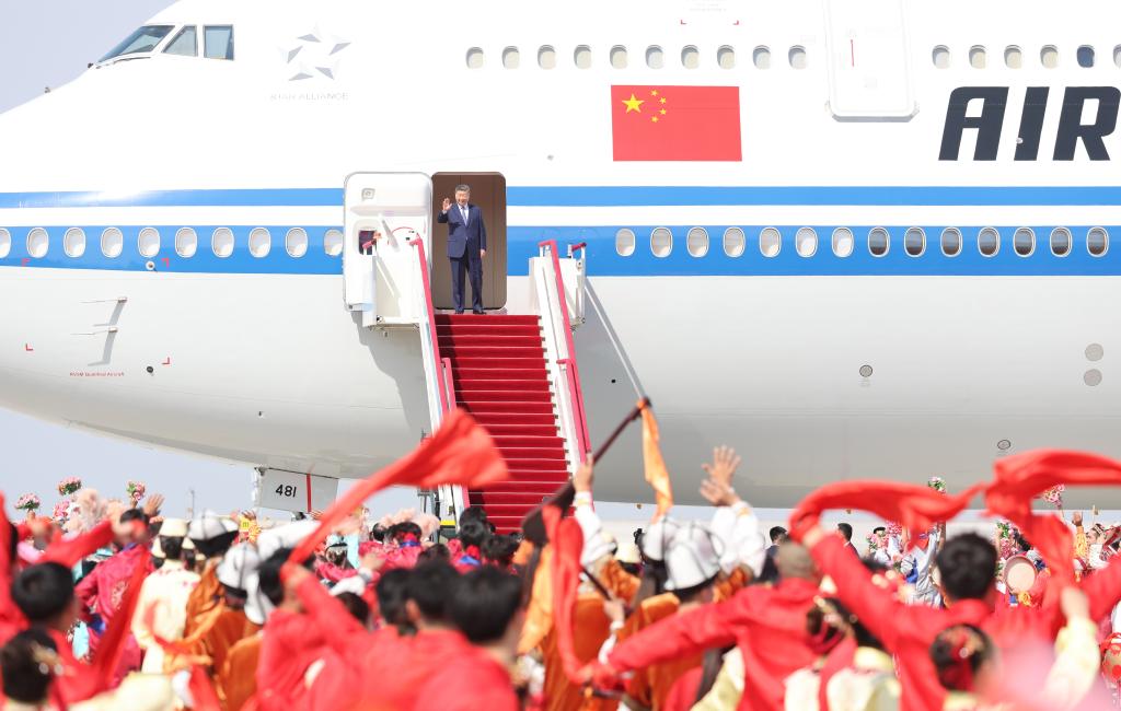 El presidente chino, Xi Jinping, también secretario general del Comité Central del Partido Comunista de China y presidente de la Comisión Militar Central, desembarca y saluda a una multitud que le aclama a su llegada a Urumqi, en la región autónoma uygur de Xinjiang, en el noroeste de China, el 23 de septiembre de 2025. Xi, encabezando una delegación central, llegó el martes a Urumqi, capital de la región autónoma uygur de Xinjiang, para asistir a las actividades conmemorativas por el 70º aniversario de la fundación de la región. (Xinhua/Yao Dawei)