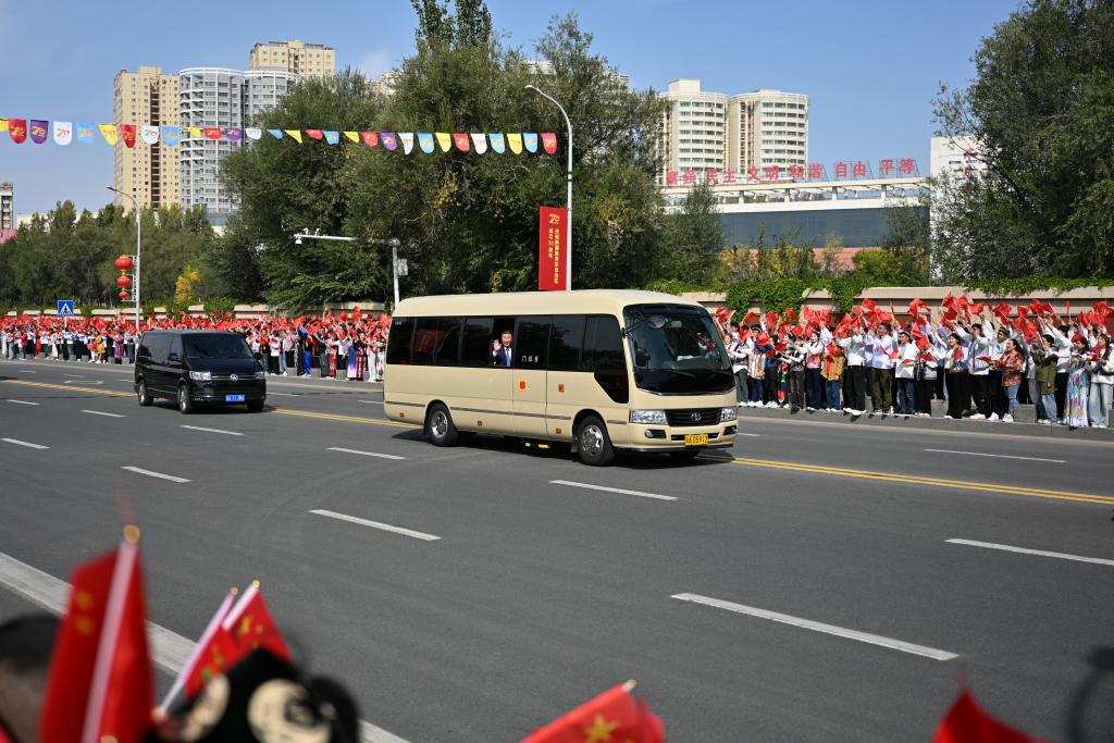 El presidente chino, Xi Jinping, también secretario general del Comité Central del Partido Comunista de China y presidente de la Comisión Militar Central, saluda a multitudes de personas a través de su ventana abierta, en Urumqi, en la región autónoma uygur de Xinjiang, en el noroeste de China, el 23 de septiembre de 2025. Xi, encabezando una delegación central, llegó el martes a Urumqi, capital de la región autónoma uygur de Xinjiang, para asistir a las actividades conmemorativas por el 70º aniversario de la fundación de la región. (Xinhua/Xin Yuewei)