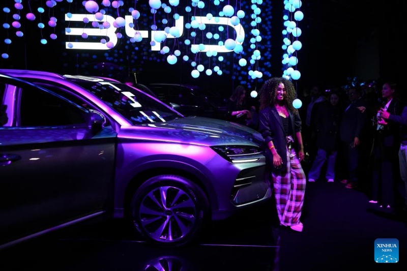 Imagen del 23 de septiembre de 2025 de una mujer posando junto a una camioneta durante el evento de lanzamiento de dos potentes camionetas de la compañía china de tecnología BYD, en Bogotá, capital de Colombia. La compañía china de tecnología BYD presentó en Bogotá su lanzamiento más relevante de 2025 en el mercado colombiano: dos potentes camionetas con tecnologías híbrida y eléctrica. (Xinhua/Andrés Moreno)