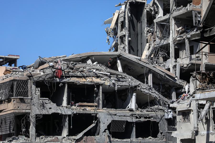 Imagen del 19 de octubre de 2025 de personas vistas en edificios destruidos, en la Ciudad de Gaza. (Xinhua/Rizek Abdeljawad)