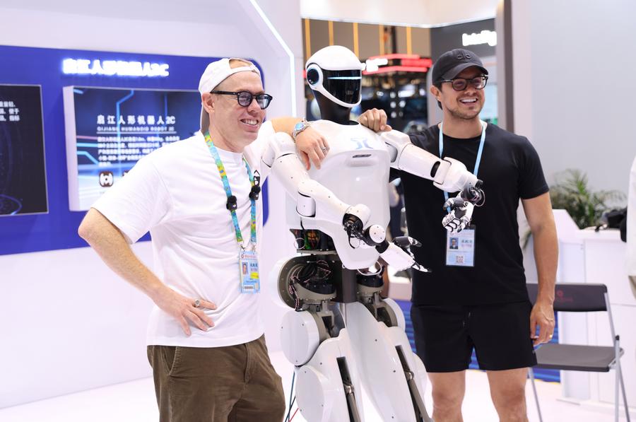 Imagen del 15 de octubre de 2025 de compradores extranjeros posando para una fotografía grupal con un robot humanoide en la Zona de Robots de Servicio durante la 138ª edición de la Feria de Importación y Exportación de China (Feria de Cantón), en Guangzhou, en la provincia de Guangdong, en el sur de China. (Xinhua/Lu Hanxin) 