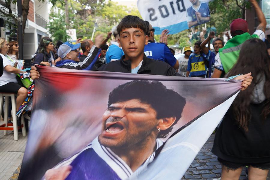 Imagen del 11 de marzo de 2025 de un simpatizante de Maradona exhibiendo una pancarta afuera del tribunal, en Buenos Aires, capital de Argentina. (Xinhua/Zhang Duo)