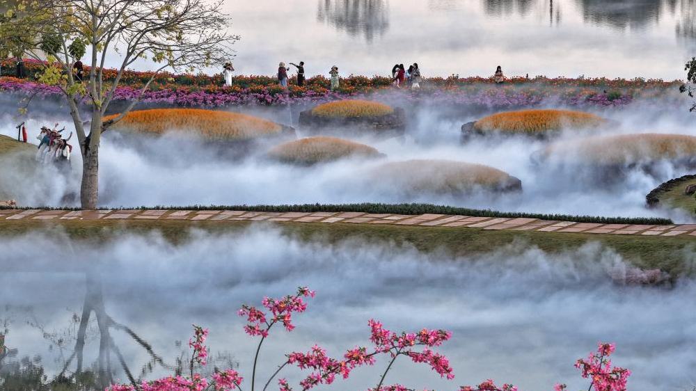Turistas disfrutan de las flores en montaña Qingxiu de Guangxi