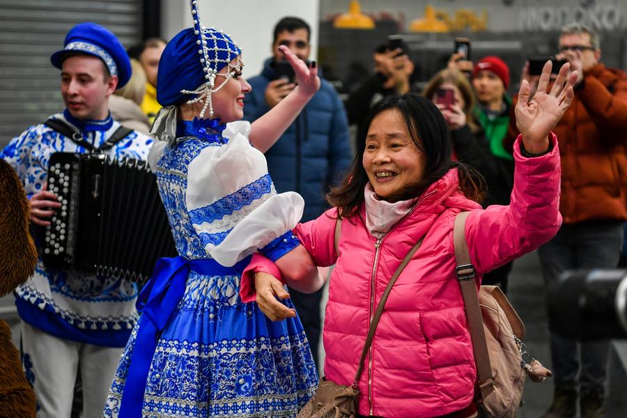 Imagen de archivo del 23 de febrero de 2023 de una viajera china bailando con una empleada durante una actividad de bienvenida en el Aeropuerto Internacional Sheremetyevo, en Moscú, Rusia. (Xinhua/Cao Yang)