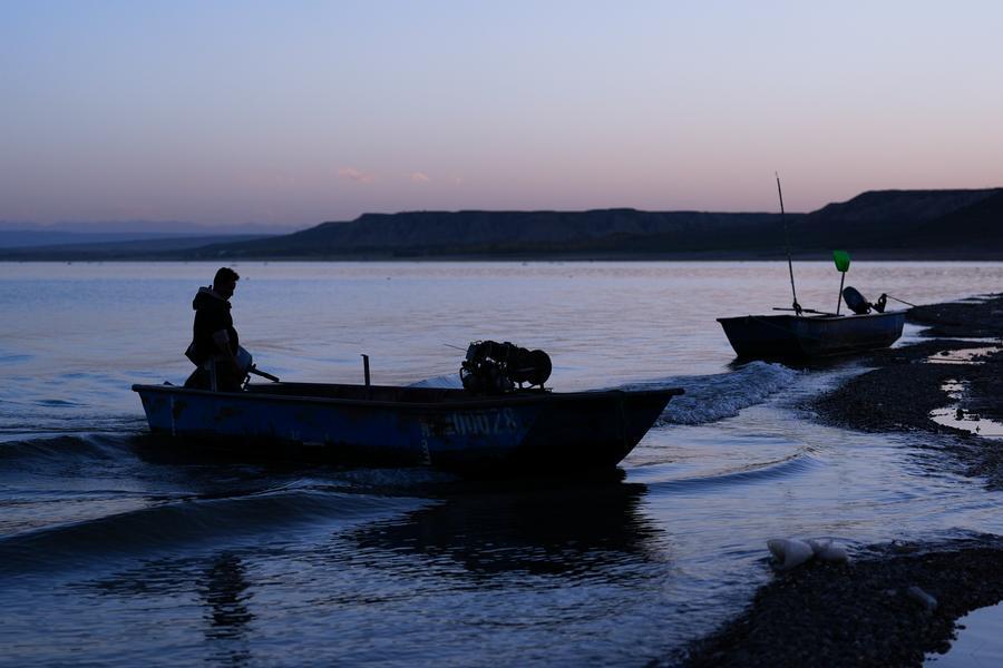 Imagen del 17 de octubre de 2025 de un pescador atracando su bote en el área de la Garganta de Longyang, en el distrito de Gonghe de la prefectura autónoma tibetana de Hainan, en la provincia de Qinghai, en el noroeste de China. (Xinhua/Qi Zhiyue) 
