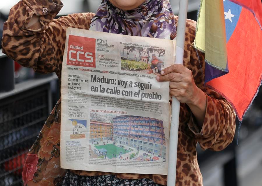 Una mujer sostiene un periódico en las inmediaciones del Palacio de Miraflores, en Caracas, capital de Venezuela, el 3 de enero de 2026. (Xinhua/Str) 