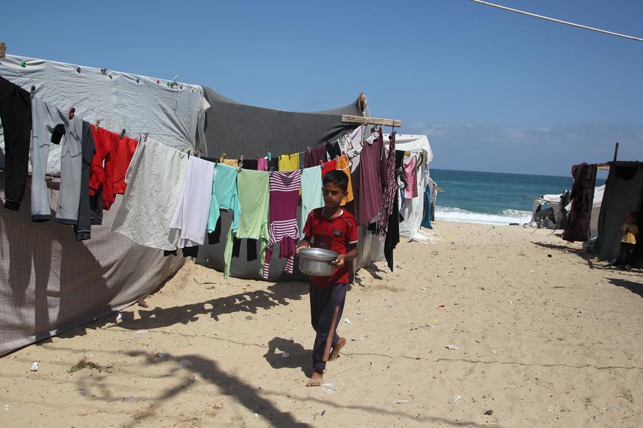 Imagen del 10 de junio de 2024 de un niño recibiendo ayuda alimentaria, en la ciudad de Rafah, en el sur de la Franja de Gaza. (Xinhua/Khaled Omar)