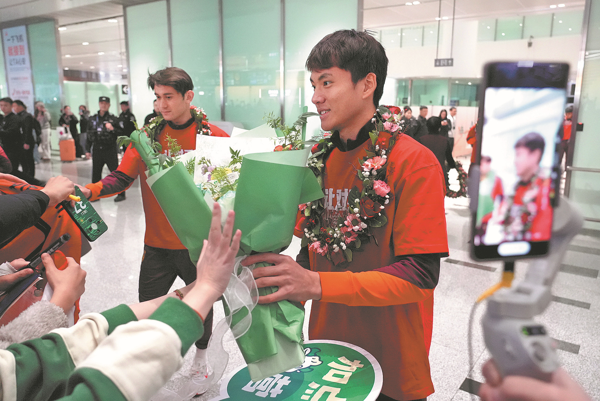 Li Hao recibe flores de un fanático tras el regreso del equipo de la Copa Asiática Sub-23 de la AFC, enero 2026. [Foto: Xinhua]