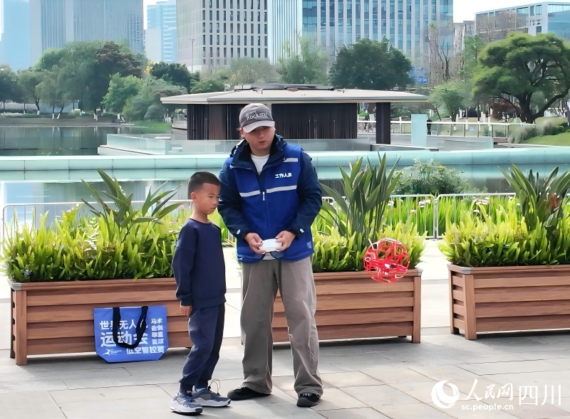 Personal demuestra uno de los drones participantes a los niños. (Foto: Yuan Manni/ Diario del Pueblo digital)