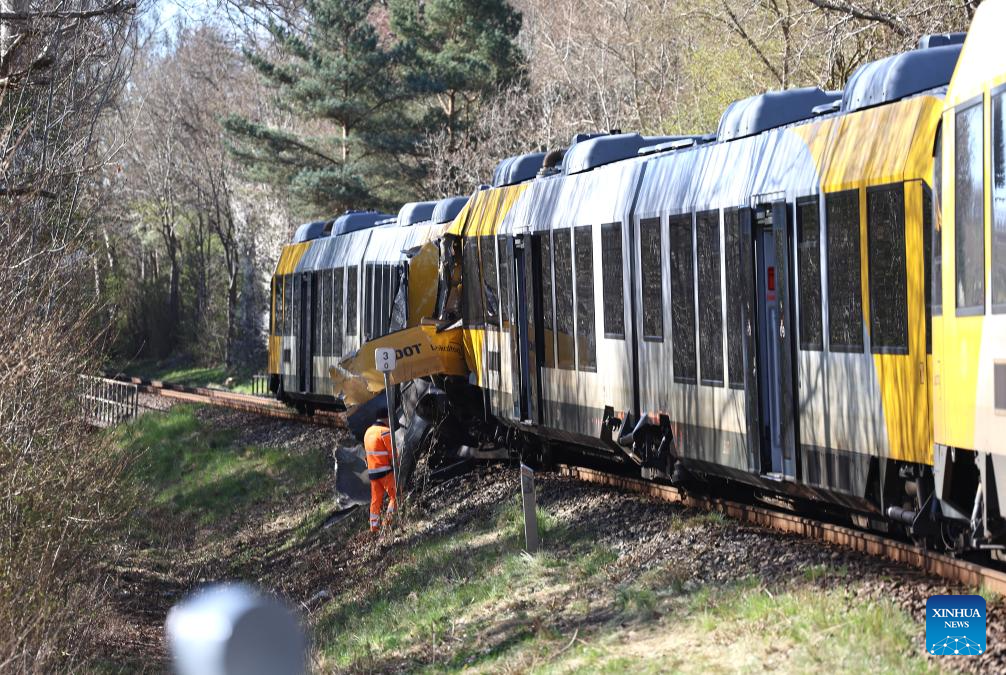 Trabajadores son vistos en el sitio donde dos trenes colisionaron en la línea Gribskov entre Hillerod y Kagerup, en Dinamarca, el 23 de abril de 2026. Un total de 18 personas resultaron heridas, cinco de ellas se encuentran en estado crítico, tras la colisión frontal de dos trenes locales ocurrida el jueves por la mañana en Dinamarca. (Xinhua/Anders Kongshaug)