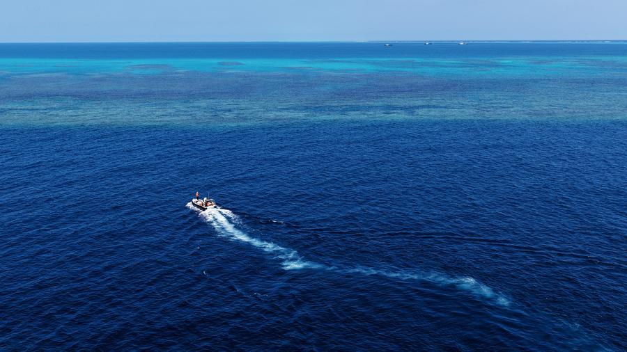 Vista aérea tomada con un dron el 2 de mayo de 2026 de un bote desplegado por el buque Chuanshan de la Guardia Costera de China (GCCh) patrullando alrededor de los arrecifes en las aguas territoriales de Huangyan Dao de China, en el Mar Meridional de China. (Xinhua/Chen Bin) 