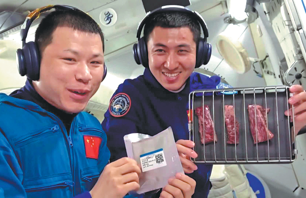 El miembro de la tripulación de Shenzhou XX, el coronel Wang Jie (a la izquierda), y el ingeniero de vuelo espacial de Shenzhou XXI, el mayor Wu Fei, se preparan para asar un plato de bistecs con pimienta negra en un horno especialmente construido, entregado este martes por la nave espacial Shenzhou XXI a la estación espacial Tiangong. (Foto: CGTN)