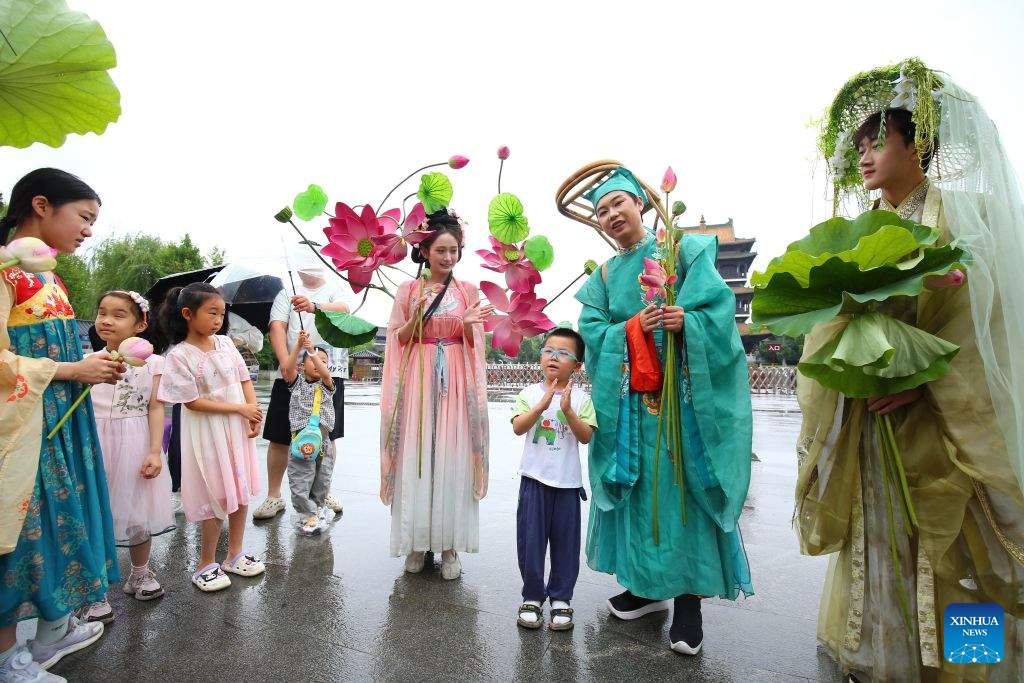 BEIJING, 19 junio, 2026 (Xinhua) -- Un niño realiza una presentación junto a artistas, en el antiguo poblado de Taierzhuang, en la ciudad de Zaozhuang, en la provincia de Shandong, en el este de China, el 19 de junio de 2026. El Festival del Bote del Dragón cae el 19 de junio este año. Las personas disfrutan de sus tres días de vacaciones de diversas maneras. (Xinhua/Li Zhijun) 