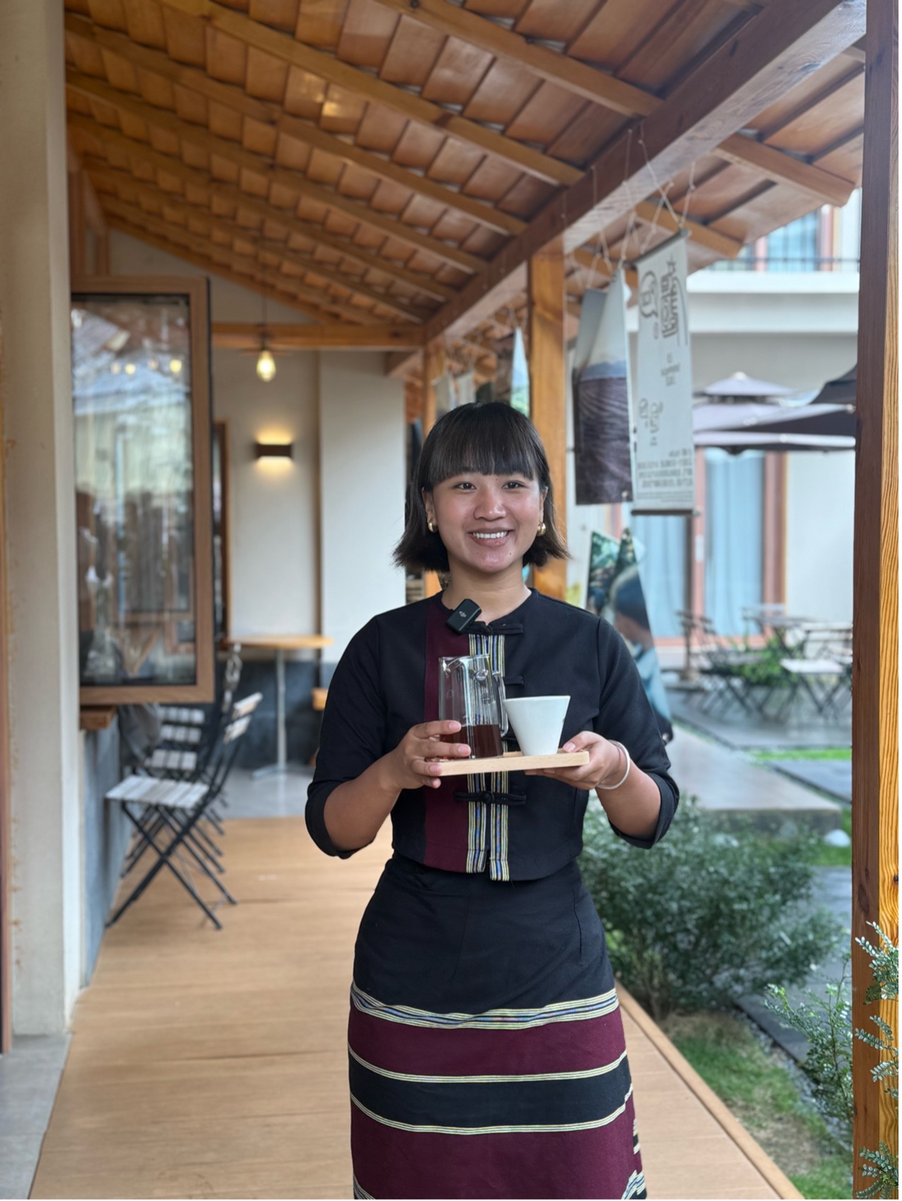 Zhao Hua y su hermana dirigen una encantadora cafetería en el condado de Menglian, provincia de Yunnan, donde venden granos de café de su propia finca mientras preservan con orgullo la herencia cultural Wa. Los invitados que disfrutan de su café pueden ver a mujeres Wa demostrar las técnicas tradicionales de tejido de brocados, transmitidas de generación en generación. (Foto: Diario del Pueblo Digital/ Hu Zunhui)