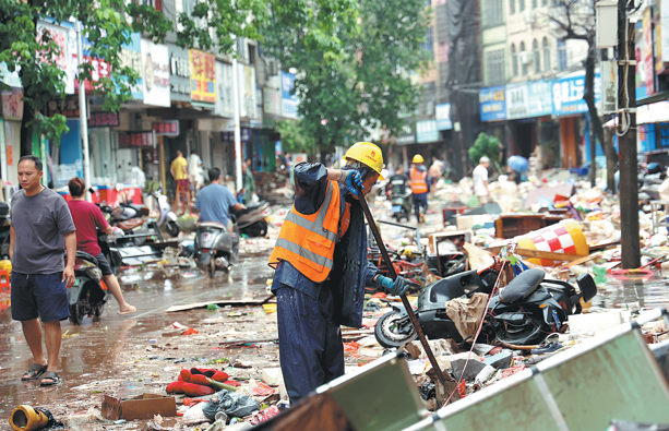 Unos trabajadores limpian los escombros dejados por las inundaciones a lo largo de una carretera en el distrito de Fangcheng en Fangchenggang, Región Autónoma Zhuang de Guangxi, este lunes. (Foto: Zhang Lai / China Daily)