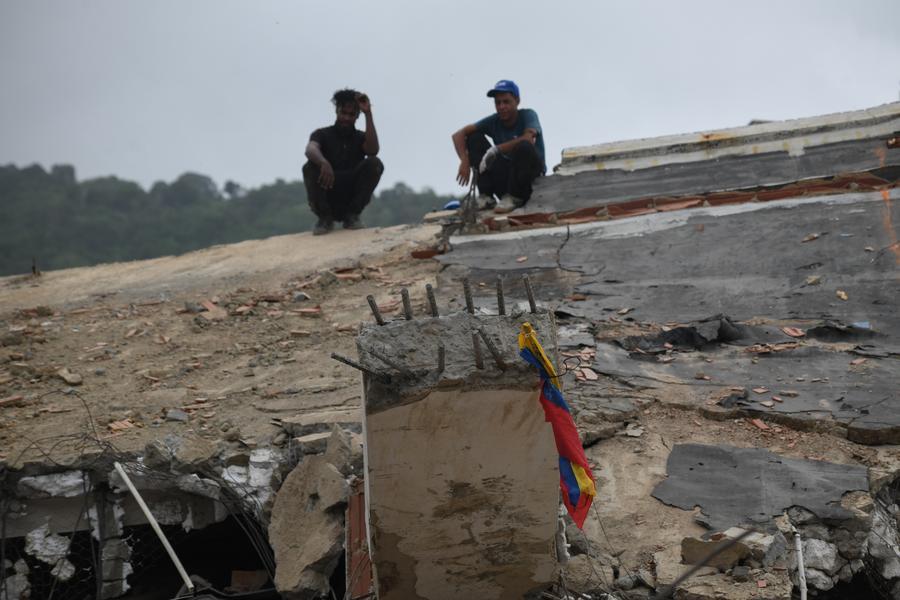 Voluntarios permanecen sobre un edificio colapsado después de que se registraran dos terremotos, en Playa Grande, estado La Guaira, Venezuela, el 13 de julio de 2026. (Xinhua/Marcos Salgado) 
