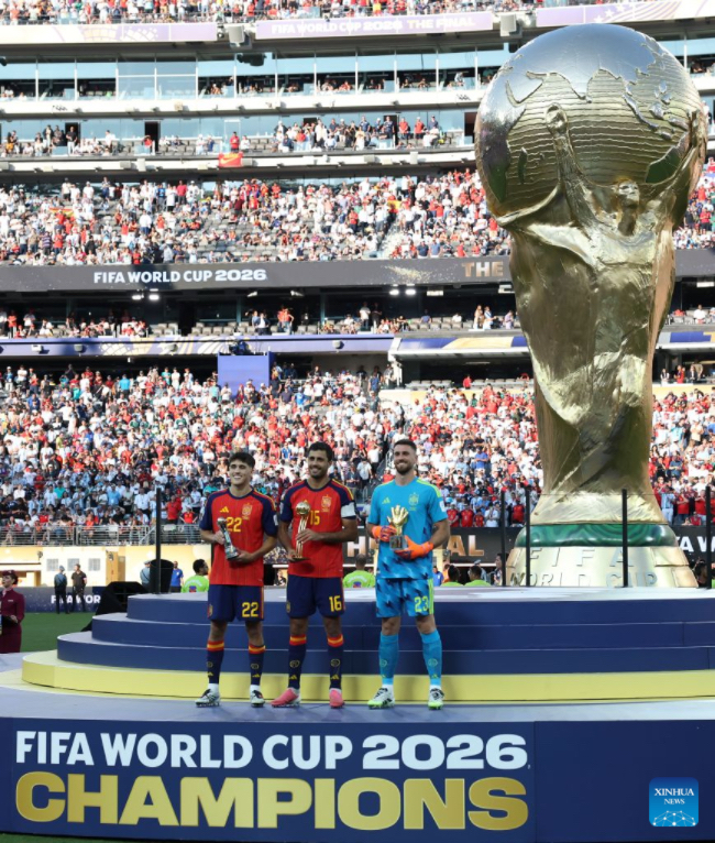 Los jugadores Pau Cubarsí (i), Rodri (c) y Unai Simón (d), de España, posan con sus trofeos durante la ceremonia de premiación al término del partido final de la Copa Mundial de la FIFA 2026 ante Argentina, celebrado en el Estadio Nueva York Nueva Jersey, en Nueva York, Estados Unidos, el 19 de julio de 2026. (Xinhua/Li Ming)