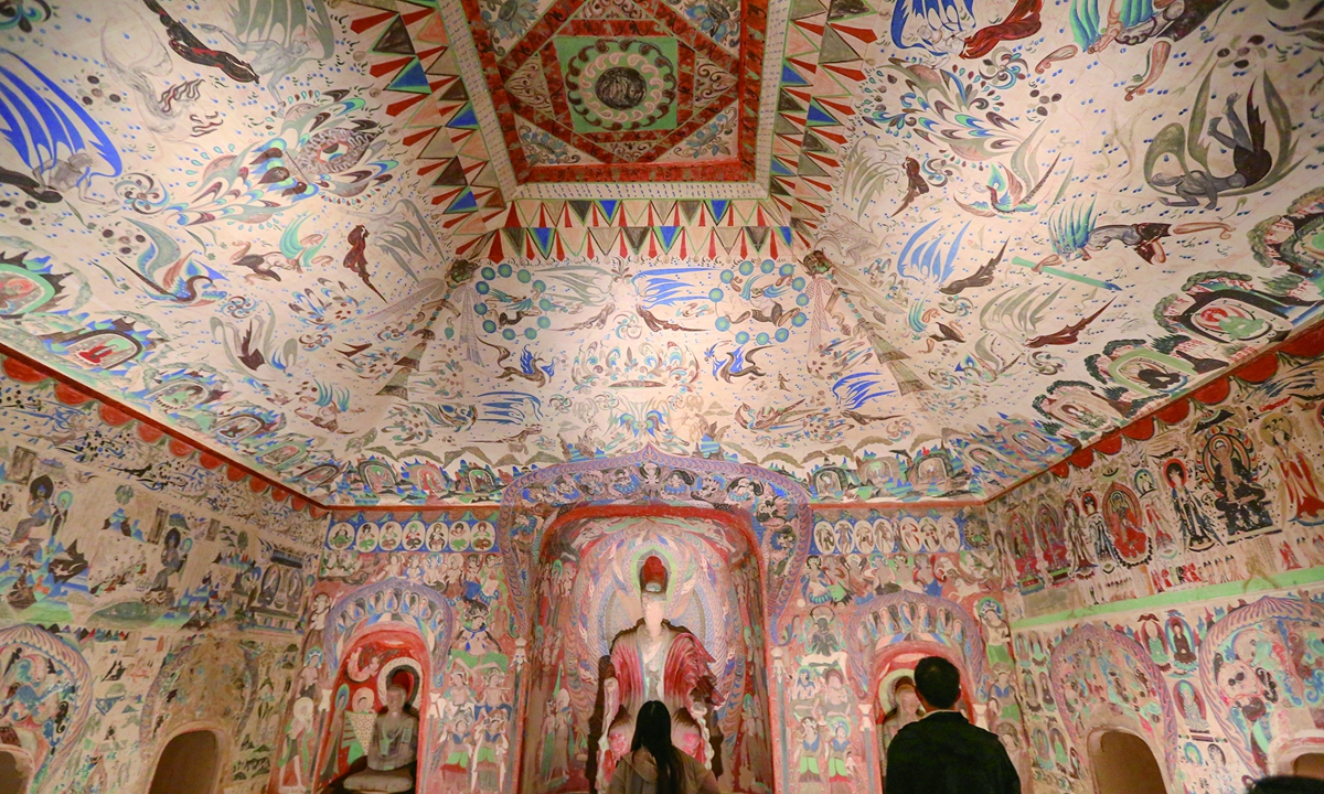 Visitantes admiran los murales de las Grutas de Mogao en Dunhuang, provincia de Gansu (noroeste de China). Foto: VCG