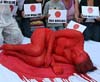 Mujer pintada de color rojo protesta ilegal pesca de ballenas por Japón