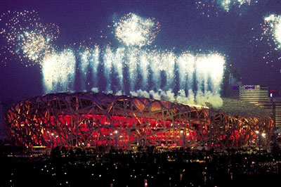 Estadio Olímpico Nacional de Beijing iluminado por luces y fuegos artificiales