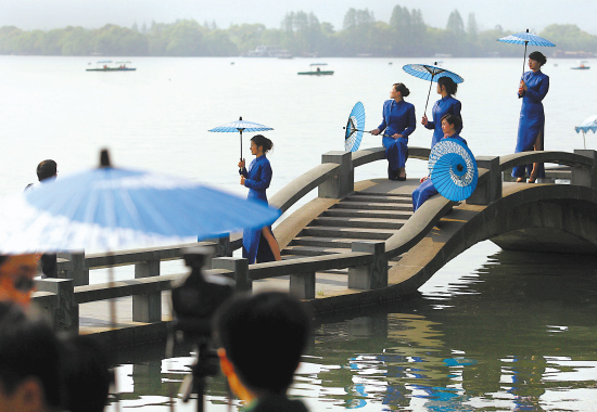 Chicas guapas posan en puente del lago del Oeste de Hangzhou, China