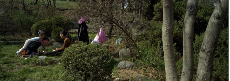 Una familia de Pyongyang haciendo un picnic en la colina de un parque.