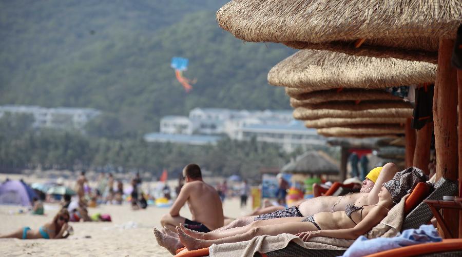 Turistas toman el sol en Sanya