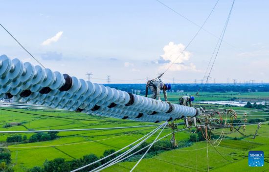 Trabajadores realizan tareas de cableado para el proyecto de transmisión de corriente continua de ultra alta tensión de ±800 kV entre Gansu y Zhejiang